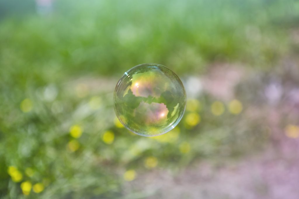 Bulle de savon devant un champ. Sérénité, introspection, joie.